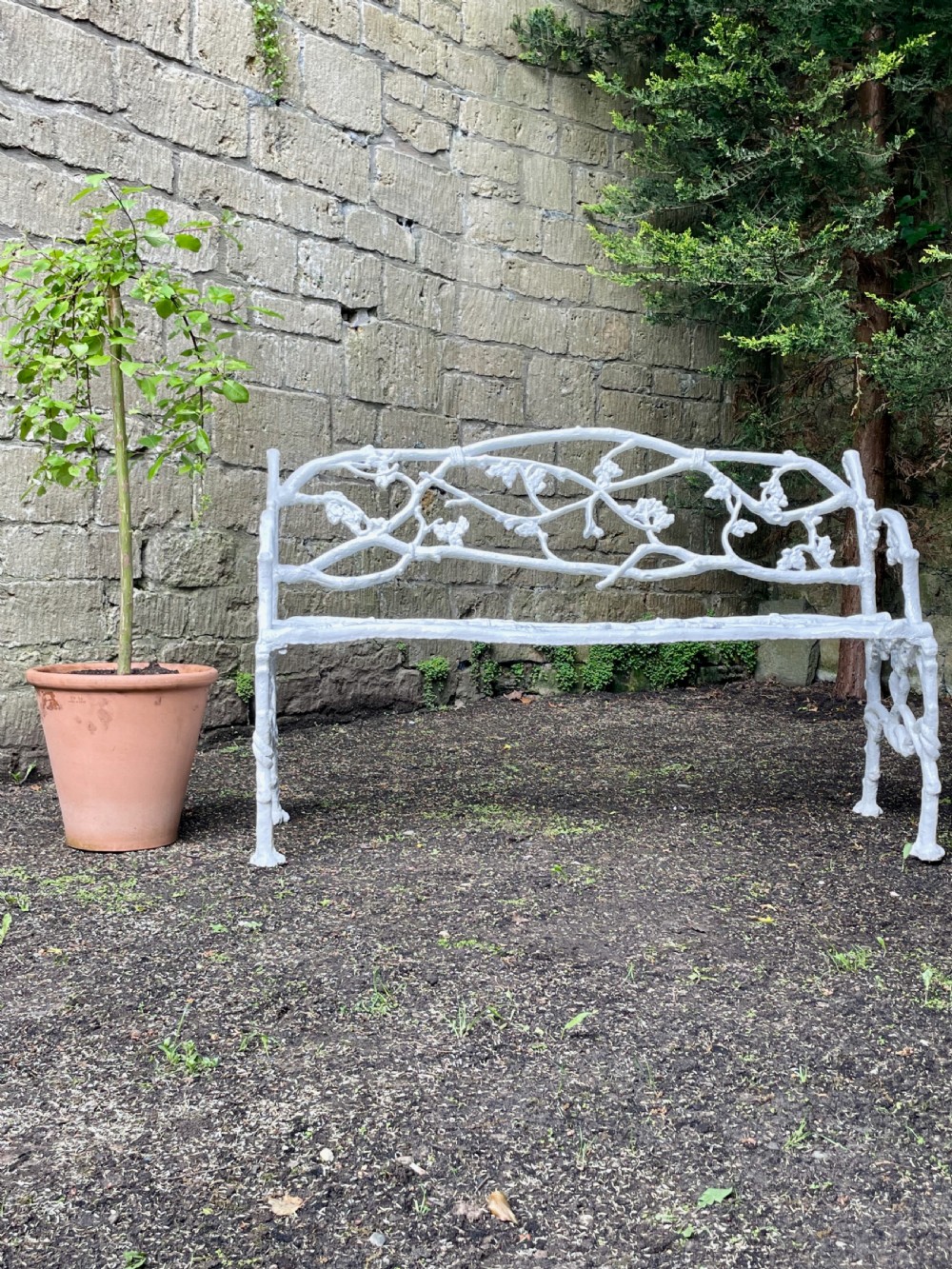 A painted white Victorian cast iron garden bench featuring an intricate intertwined branch and twig motif. View XIII