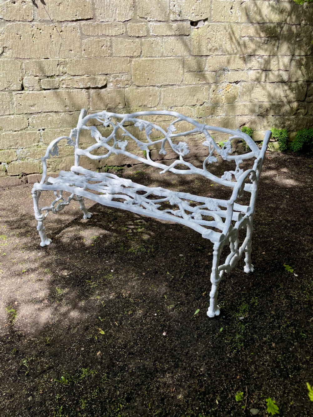 A painted white Victorian cast iron garden bench featuring an intricate intertwined branch and twig motif. View XVII