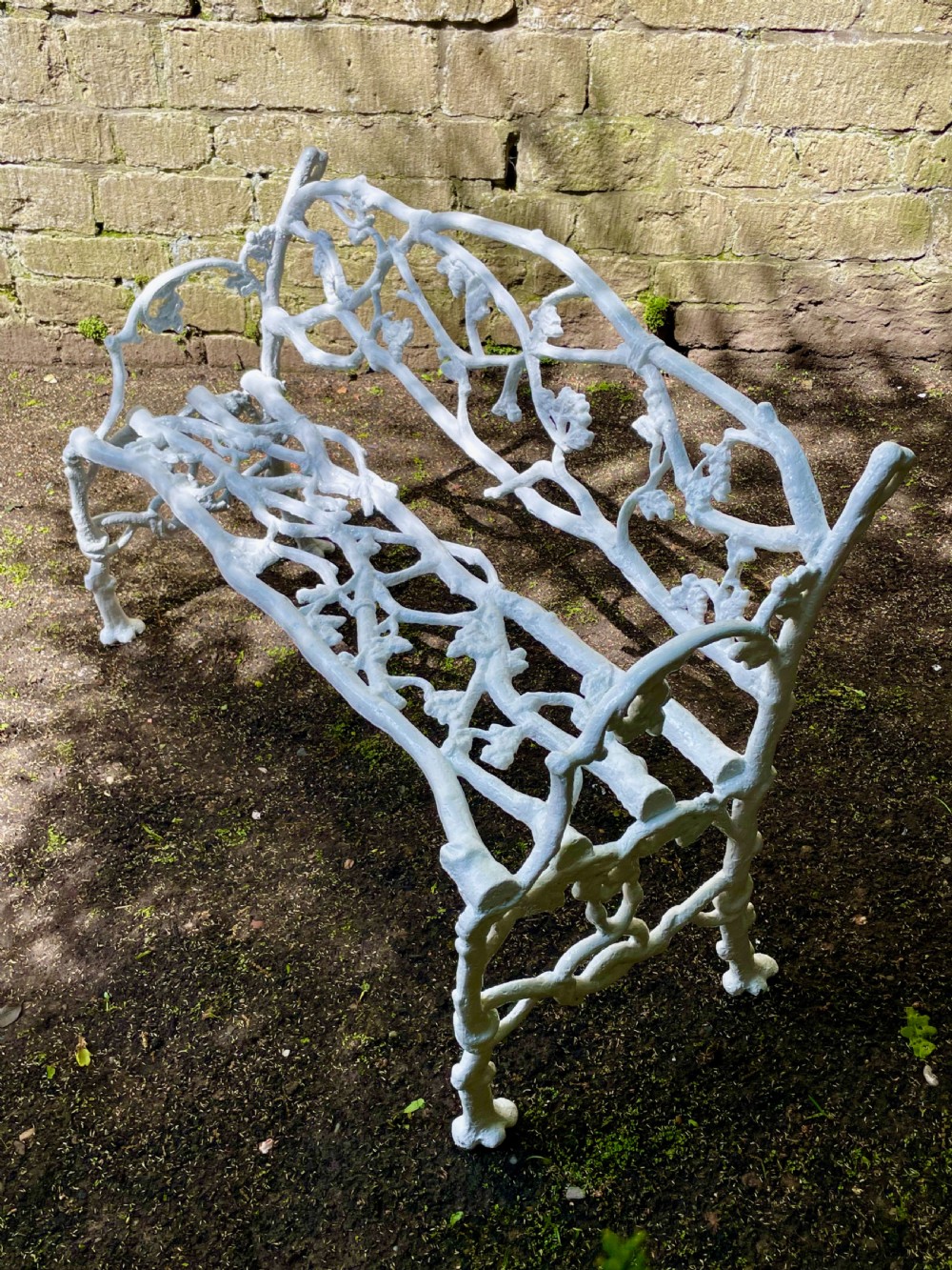 A painted white Victorian cast iron garden bench featuring an intricate intertwined branch and twig motif. View XVIII