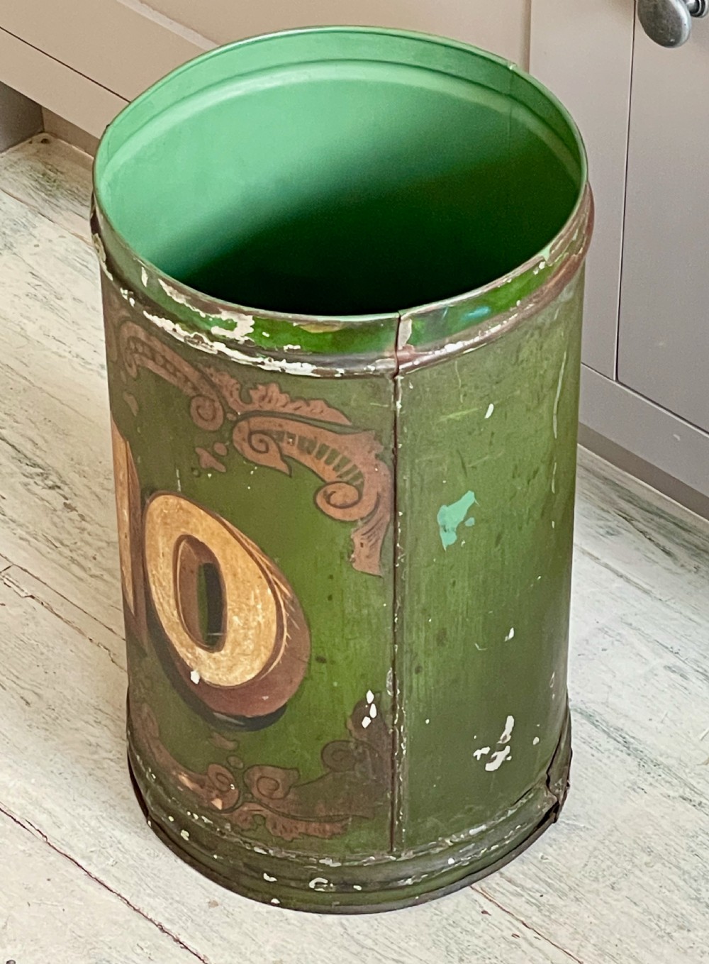 A cylindrical green painted antique metal tea canister featuring gold scrollwork and the painted number ten. View III