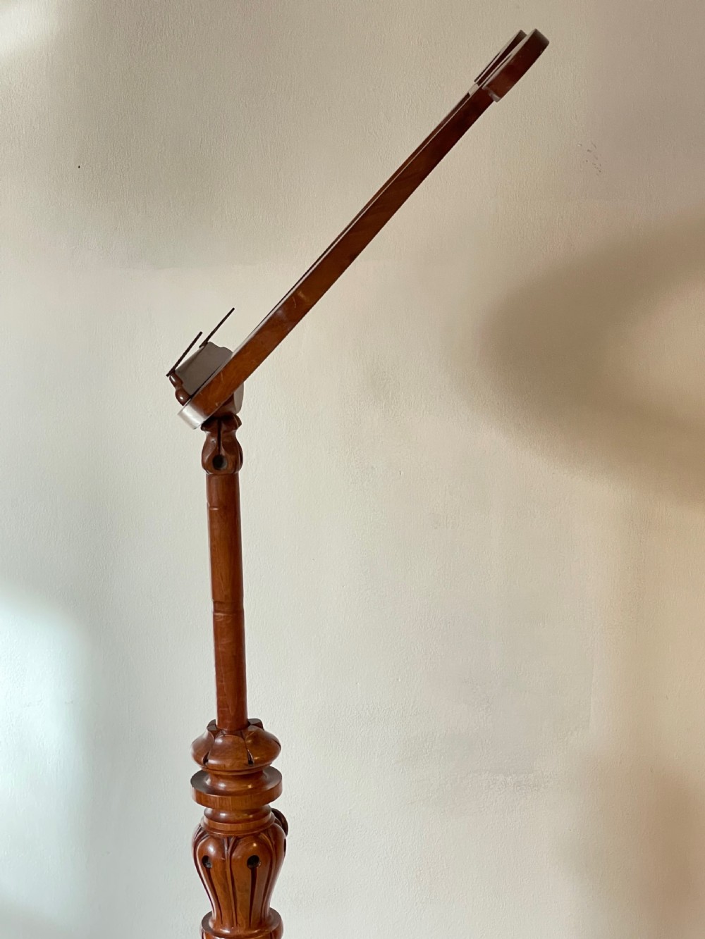 A nineteenth-century mahogany music stand featuring a lyre-shaped rest, a carved turned stem, and a triform base terminating in paw feet. View VII