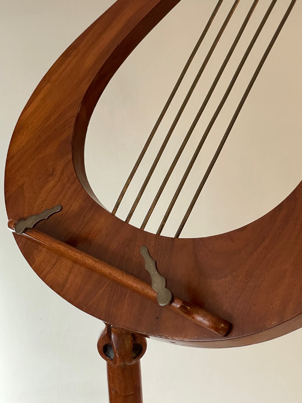 A nineteenth-century mahogany music stand featuring a lyre-shaped rest, a carved turned stem, and a triform base terminating in paw feet. View XIV