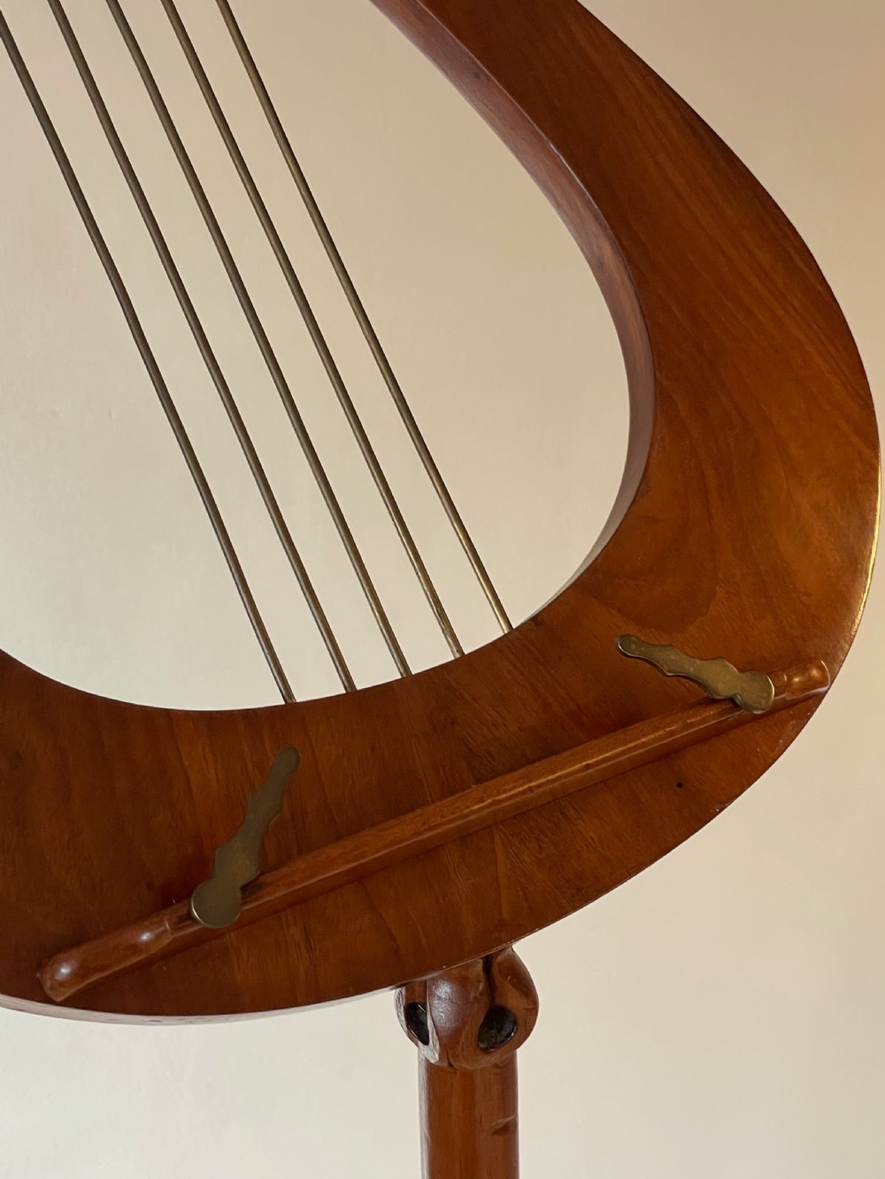 A nineteenth-century mahogany music stand featuring a lyre-shaped rest, a carved turned stem, and a triform base terminating in paw feet. View XVI