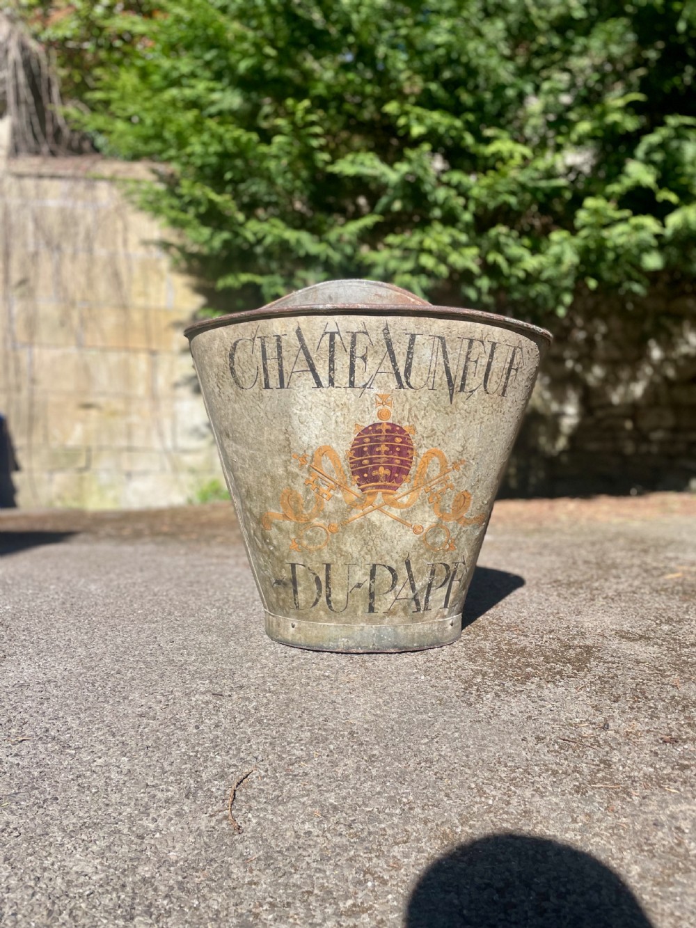 A tapered 19th-century metal grape hod featuring a distressed beige finish with hand-painted Chateauneuf-du-Pape lettering and a papal crest. View IV