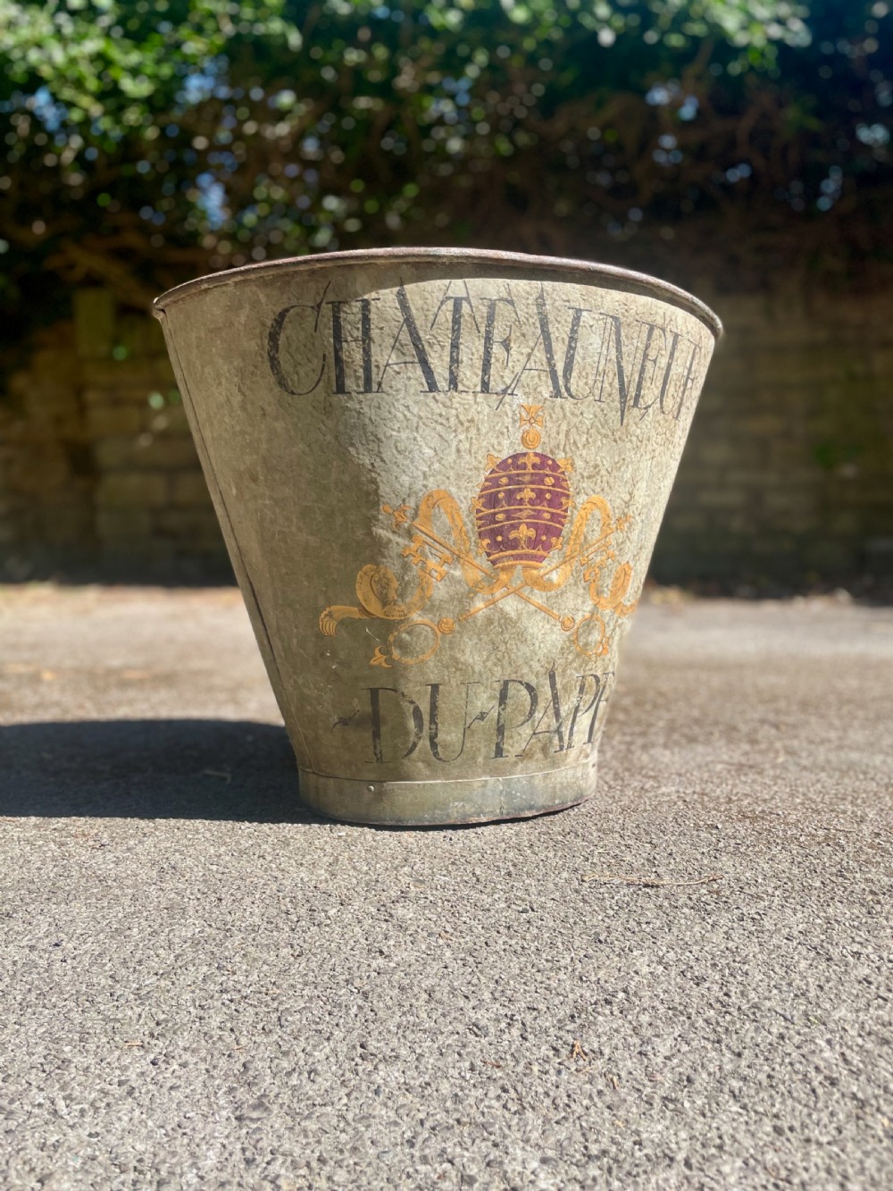 A tapered 19th-century metal grape hod featuring a distressed beige finish with hand-painted Chateauneuf-du-Pape lettering and a papal crest. View V