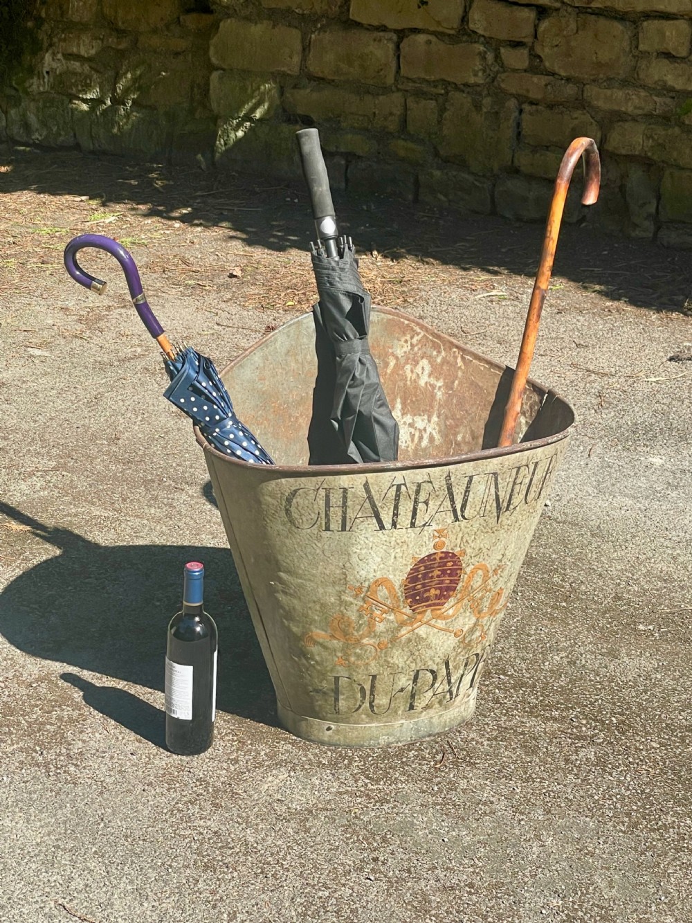 A tapered 19th-century metal grape hod featuring a distressed beige finish with hand-painted Chateauneuf-du-Pape lettering and a papal crest. View XII