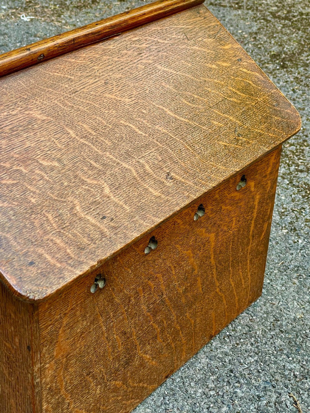 An antique Victorian warm brown oak dog kennel featuring a pitched roof, arched entrance aperture, and trefoil ventilation cutouts along the side. View V