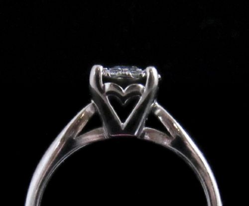 fig 1. An 18kt white gold ring featuring a raised round cluster setting set with multiple brilliant-cut diamonds.