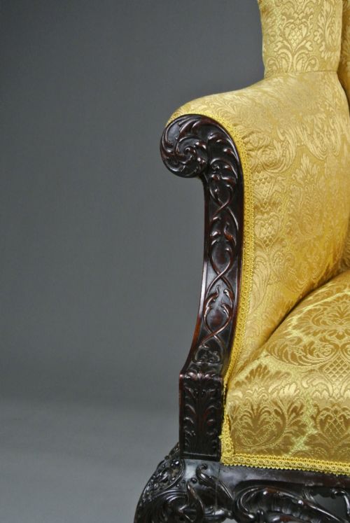fig 2. A Georgian mahogany wingback armchair upholstered in patterned gold damask fabric, featuring carved cabriole legs and an ornate apron.