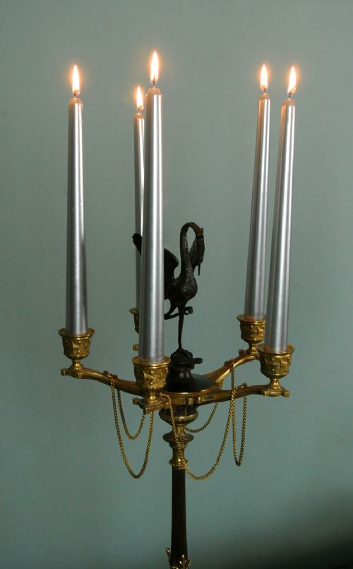 fig 2. A pair of tall nineteenth-century dark bronze and gilded ormolu candelabra featuring crane finials, hanging chains, multi-nozzle arms, and tripod claw bases.