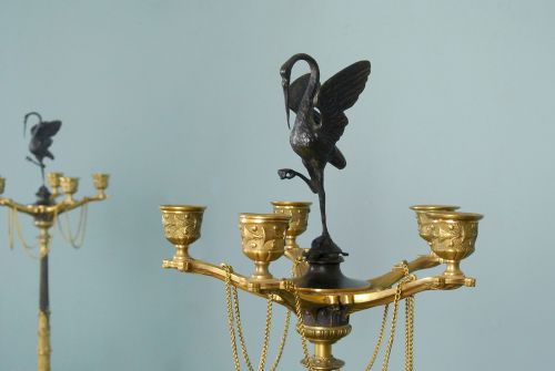 fig 3. A pair of tall nineteenth-century dark bronze and gilded ormolu candelabra featuring crane finials, hanging chains, multi-nozzle arms, and tripod claw bases.