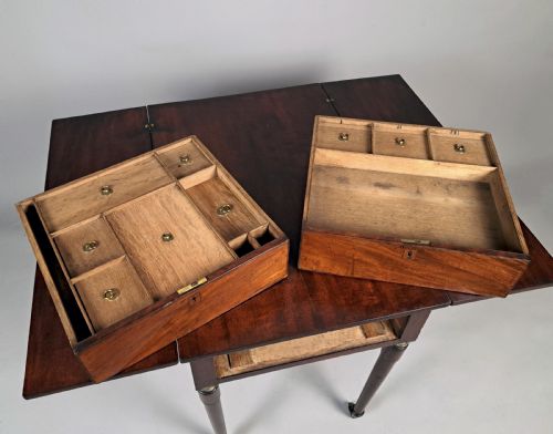 fig 2. A George III mahogany campaign table with a split hinged top, flame mahogany drawer front, brass collar mounts, turned tapering legs, and brass castors.