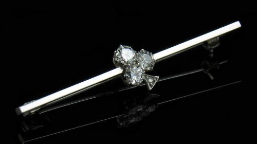 fig 1. An Art Deco 18ct white gold bar brooch featuring a central trefoil cluster of old-cut diamonds on a slender horizontal bar.