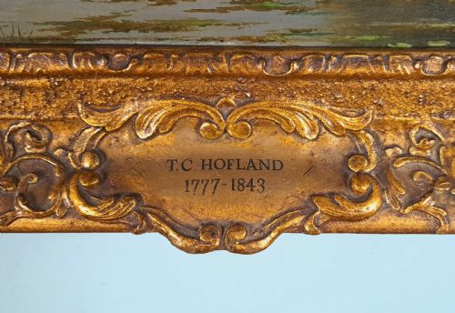 fig 2. An early 19th-century English oil on board landscape painting depicting a pastoral river scene with cattle and castle ruins, housed within an ornate gold giltwood frame.