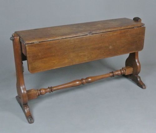 fig 1. A Georgian solid teak campaign table featuring a rectangular tilt-top surface supported by shaped side trestles connected by a central turned stretcher.