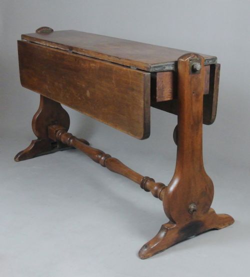fig 2. A Georgian solid teak campaign table featuring a rectangular tilt-top surface supported by shaped side trestles connected by a central turned stretcher.