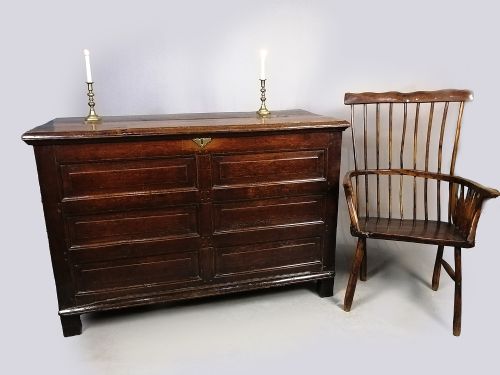 fig 1. A seventeenth-century dark oak coffer featuring six rectangular raised panels on the front facade and a central brass keyhole escutcheon.