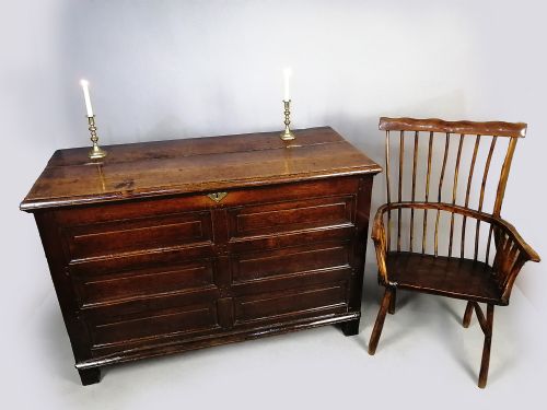 fig 2. A seventeenth-century dark oak coffer featuring six rectangular raised panels on the front facade and a central brass keyhole escutcheon.