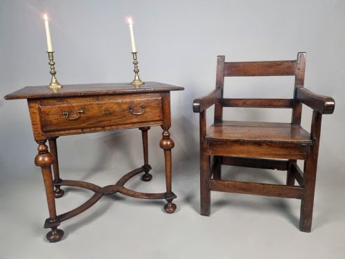 fig 1. A Queen Anne period oak and elm lowboy featuring a single drawer with brass drop handles, turned legs, and a curved X-frame stretcher.