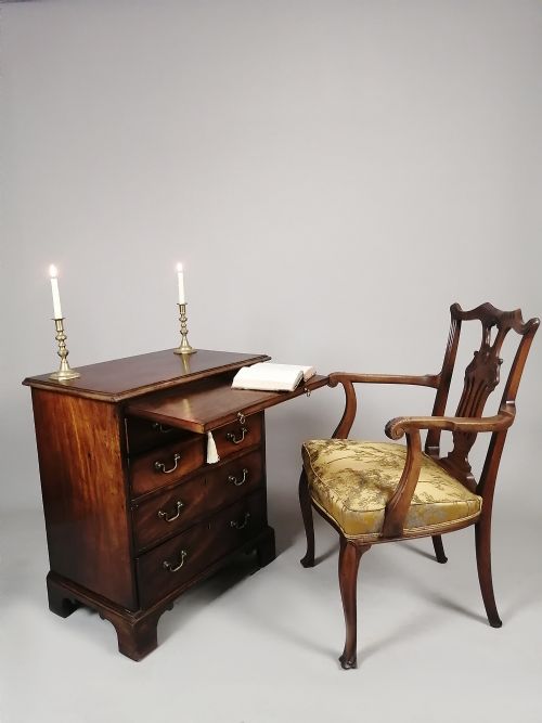 fig 2. A small George III Cuban mahogany bachelors chest featuring four graduated drawers, brass swan-neck handles, a brushing slide, and bracket feet.