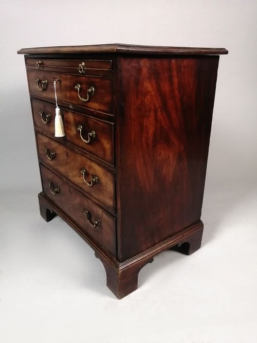 fig 4. A small George III Cuban mahogany bachelors chest featuring four graduated drawers, brass swan-neck handles, a brushing slide, and bracket feet.