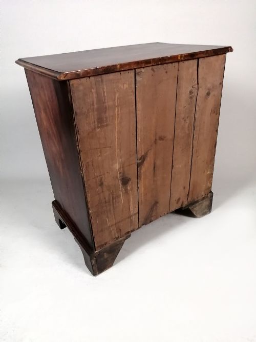 fig 6. A small George III Cuban mahogany bachelors chest featuring four graduated drawers, brass swan-neck handles, a brushing slide, and bracket feet.
