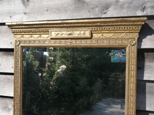 fig 1. A tall rectangular Regency giltwood pier mirror featuring a carved classical frieze, fluted side pilasters, and a reflective glass plate.