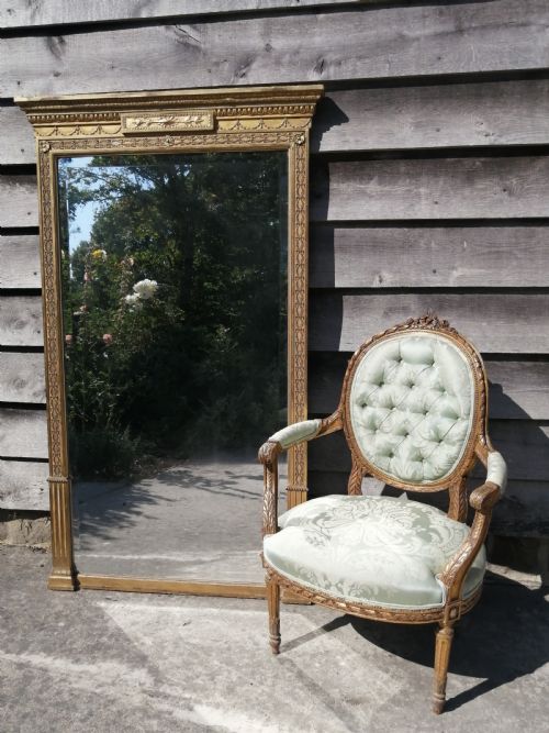 fig 2. A tall rectangular Regency giltwood pier mirror featuring a carved classical frieze, fluted side pilasters, and a reflective glass plate.