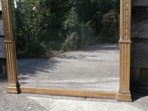 fig 3. A tall rectangular Regency giltwood pier mirror featuring a carved classical frieze, fluted side pilasters, and a reflective glass plate.