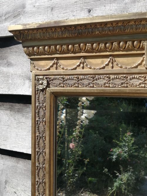 fig 4. A tall rectangular Regency giltwood pier mirror featuring a carved classical frieze, fluted side pilasters, and a reflective glass plate.