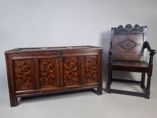 fig 1. A 17th-century dark oak coffer featuring four front panels with floral marquetry inlay and a panelled hinged top.