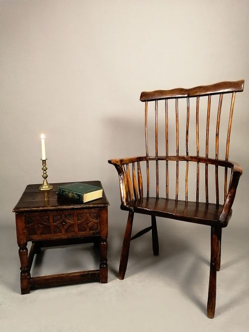 fig 1. A 17th-century dark oak box stool featuring a carved geometric frieze, turned legs, and lower stretchers.