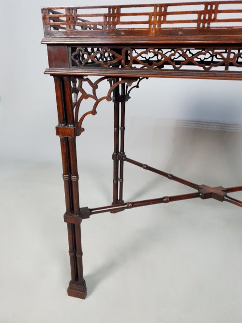 fig 3. A dark padauk Chippendale style silver table featuring a pierced gallery rim, fretwork frieze, cluster legs, and turned stretchers.