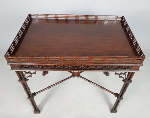 fig 4. A dark padauk Chippendale style silver table featuring a pierced gallery rim, fretwork frieze, cluster legs, and turned stretchers.