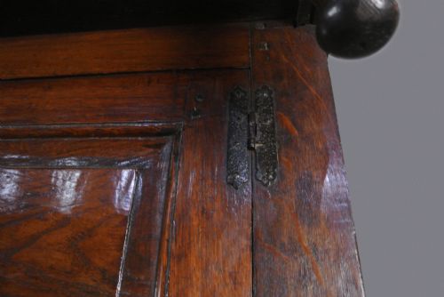 fig 3. An 18th-century dark oak court cupboard featuring a carved date of 1723, upper recessed cabinet with drop finials, and fielded lower door panels.
