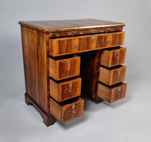 fig 3. An 18th-century George II yew wood kneehole dressing table with multiple drawers, brass drop handles, and a central recessed cupboard.