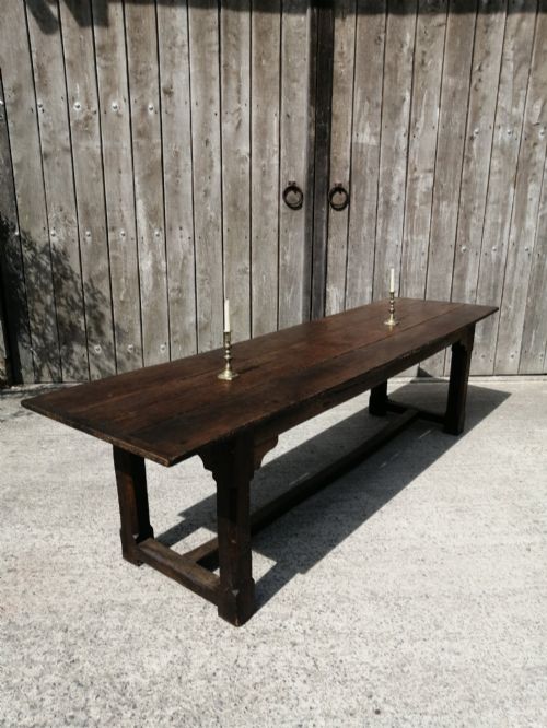 fig 1. A long George I oak and elm refectory table featuring a plank top and low stretcher base.