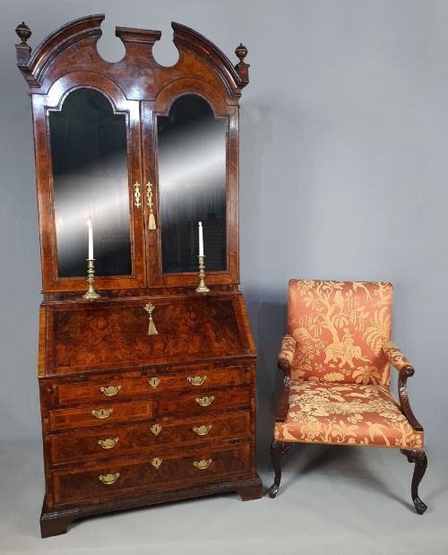 fig 1. An early 18th-century Queen Anne burr walnut bureau bookcase featuring an open double-domed upper cabinet with fitted interior pigeonholes above a fall-front desk section.