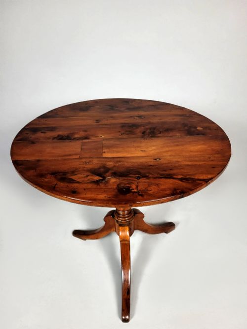 fig 2. A Georgian yew wood circular tilt-top wine table featuring a turned central pedestal and a tripod base.