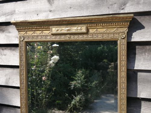 fig 4. A tall rectangular Georgian giltwood pier mirror featuring a breakfront cornice, floral tablet, and fluted pilasters around the original mirror glass.