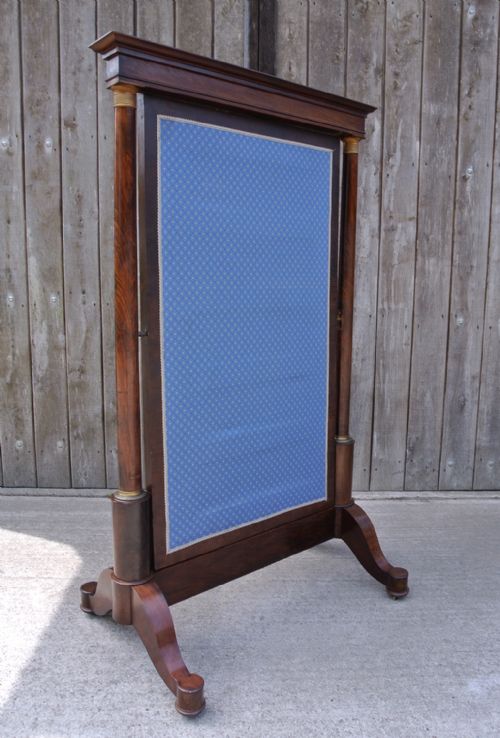 fig 2. A Georgian mahogany cheval mirror featuring architectural column supports, brass candle sconces, a pedimented top, and a swivelling full-length mirror glass.