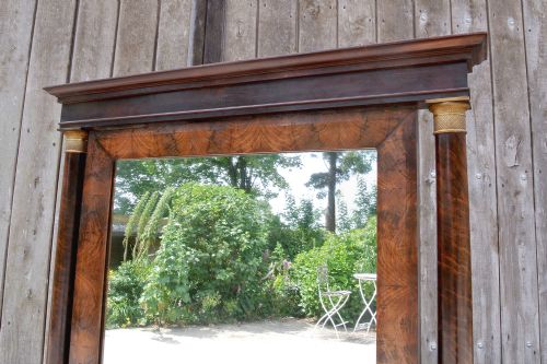 fig 3. A Georgian mahogany cheval mirror featuring architectural column supports, brass candle sconces, a pedimented top, and a swivelling full-length mirror glass.
