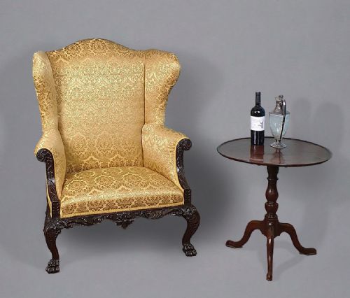 fig 1. A Georgian carved mahogany wingback armchair upholstered in patterned gold damask fabric with carved cabriole legs and claw feet.