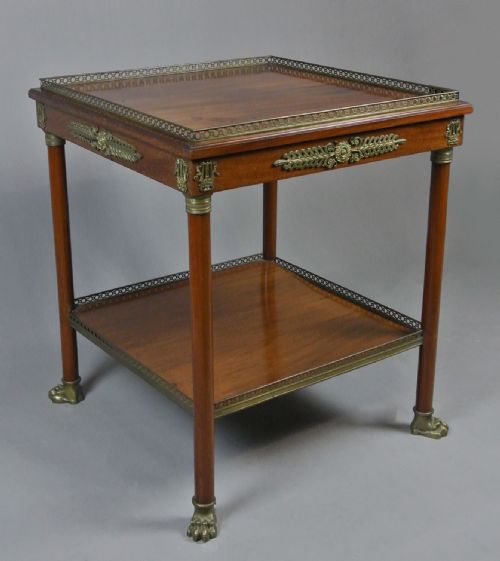 fig 1. A two-tiered Regency mahogany centre table featuring pierced brass gallery rims, decorative brass frieze mounts, cylindrical columns, and cast brass paw feet.