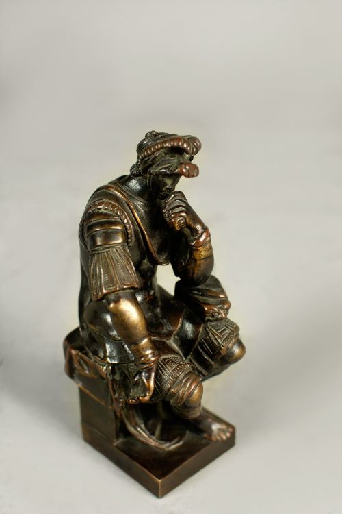 fig 1. A dark patinated bronze figure depicting Lorenzo de Medici seated in a thoughtful pose on a rectangular base.