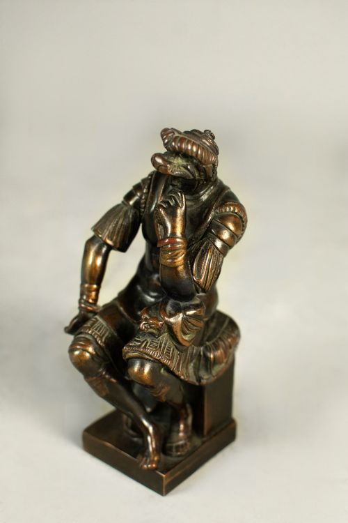 fig 2. A dark patinated bronze figure depicting Lorenzo de Medici seated in a thoughtful pose on a rectangular base.