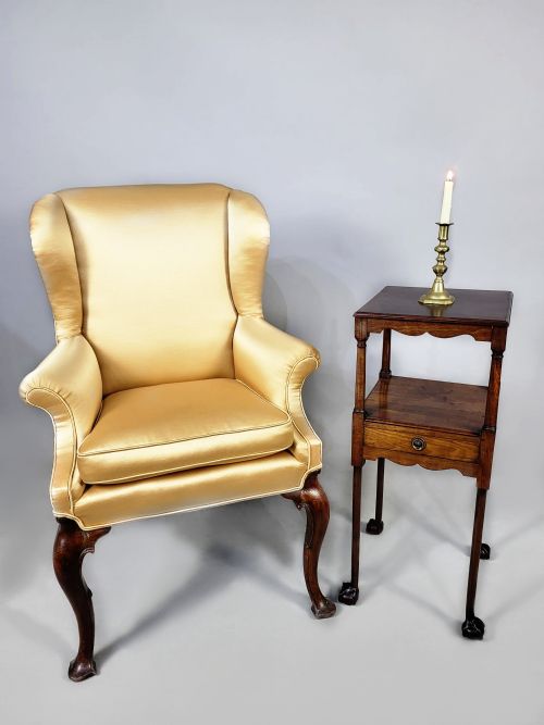 fig 2. An antique George III Cuban mahogany nightstand featuring tiered shelves, a central drawer, turned column supports, scalloped aprons, and carved claw and ball feet.