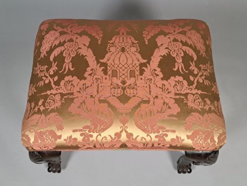 fig 2. An 18th-century Irish George II mahogany footstool with shell-carved cabriole legs, claw and ball feet, and patterned damask top.