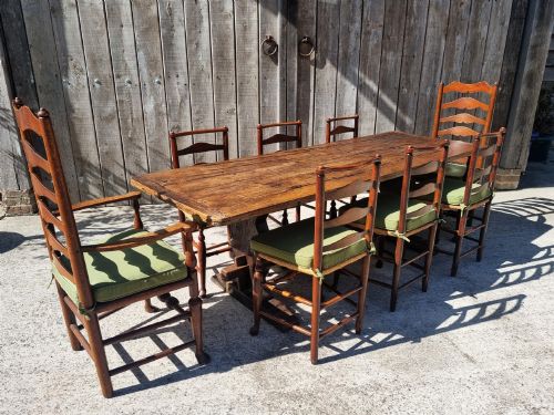 fig 2. A set of eight 19th-century wooden country dining chairs featuring woven rush seats with green seat pads, shaped horizontal back slats, and turned legs.