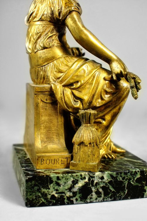 fig 2. A nineteenth-century gilt bronze sculpture depicting the seated Roman goddess Ceres holding a sheaf of wheat on a square green marble base.